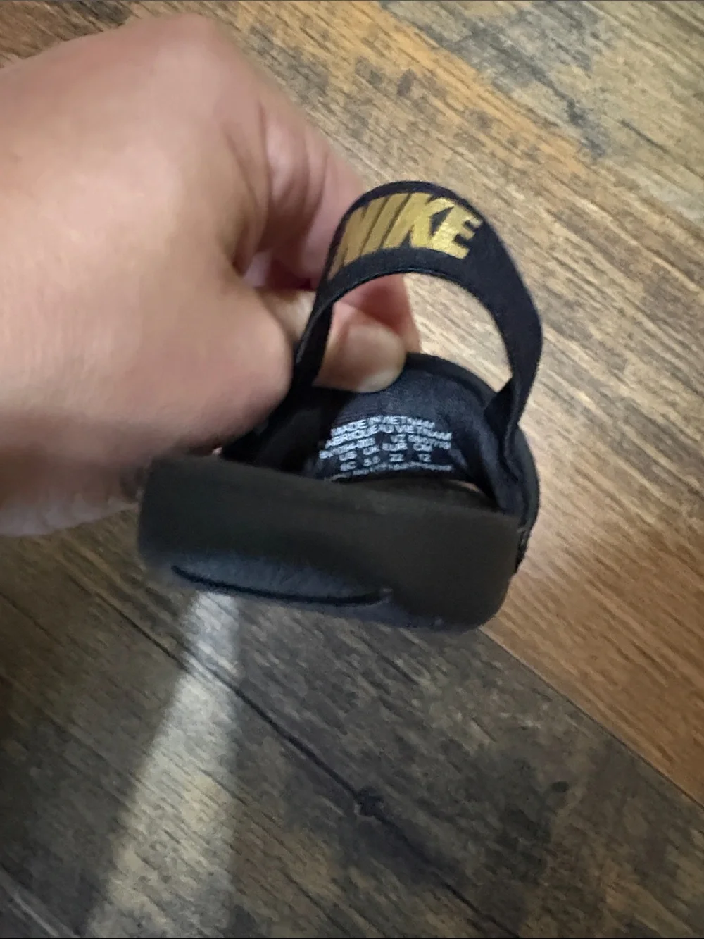 Nike Kids Black Slide Sandals with Gold Swoosh Accent